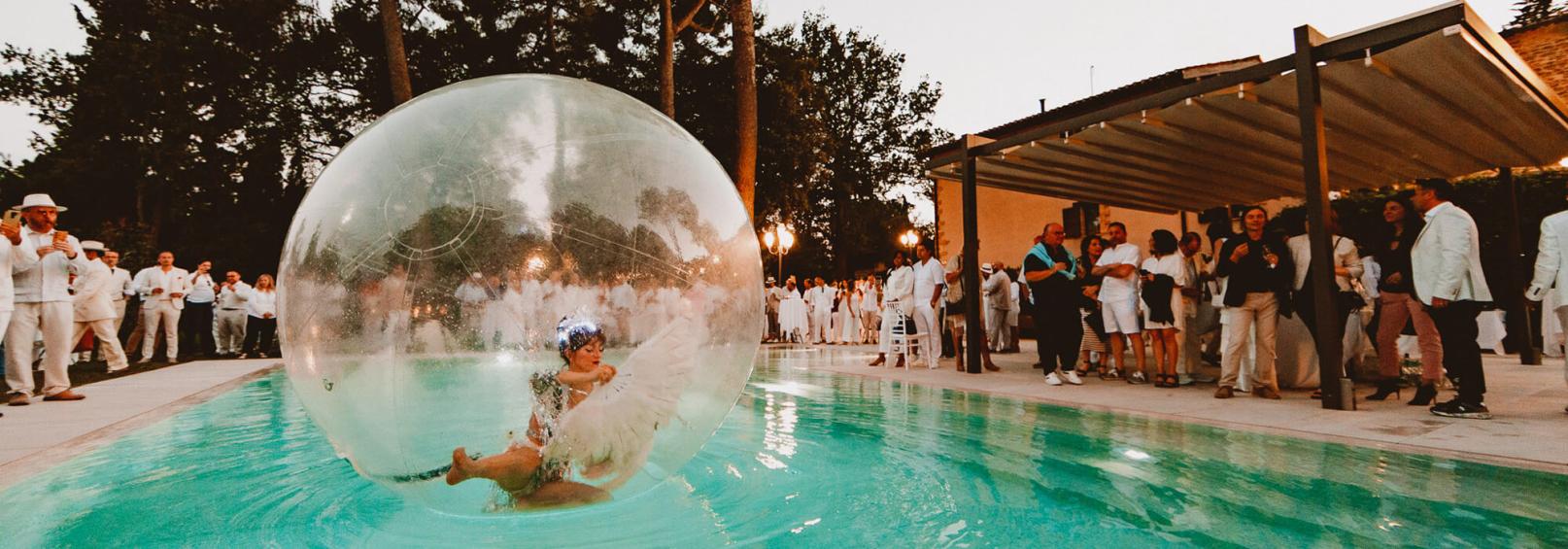 Party with pool entertainment and a performer in a giant bubble.